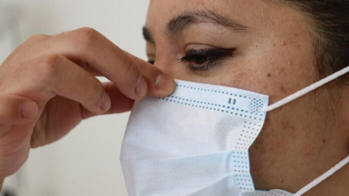 mujer-ajusta-su-cubrebocas-para-una-efectiva-proteccion-contra-el-covid-19